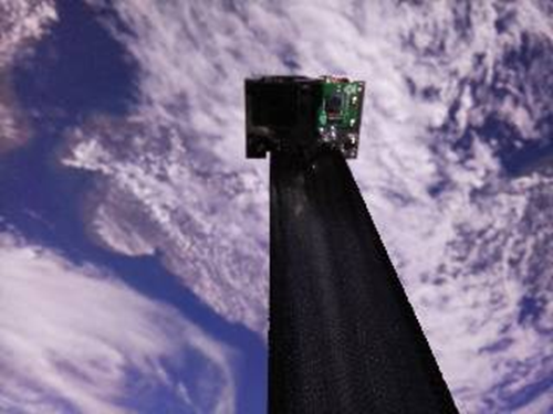 TPA-1 Cubesat travelling over the UK with a Rolatube BRC boom deploying an inspection camera away from the satellite for routine observations.The power and data cables are embedded into the composite boom.